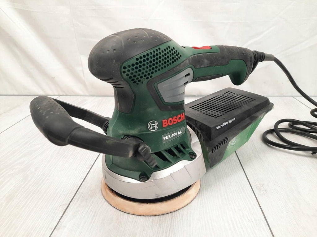 une ponceuse bosch pex 400 ae sur du carreau