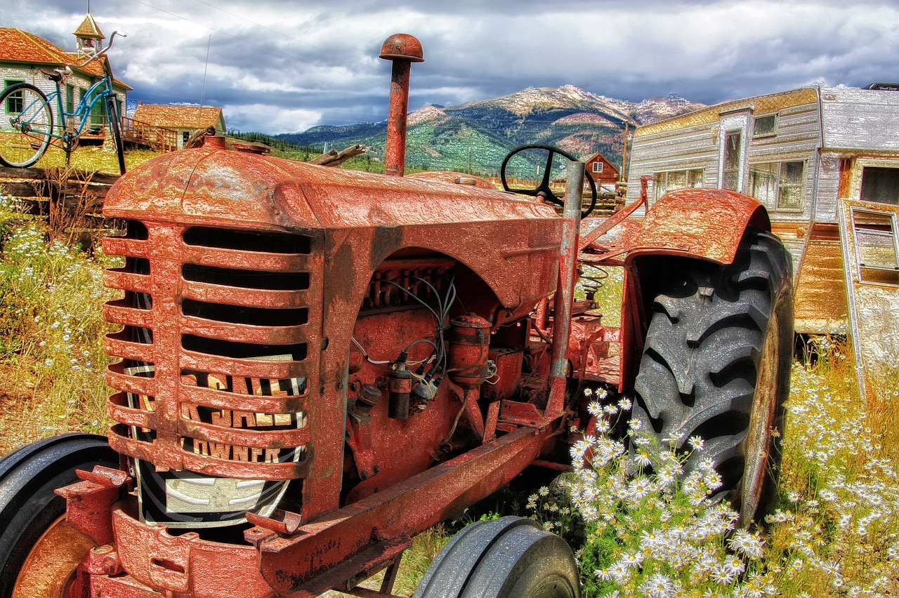 un agriculteur cherchant à comprendre comment poncer un tracteur et le repeindre plus tard