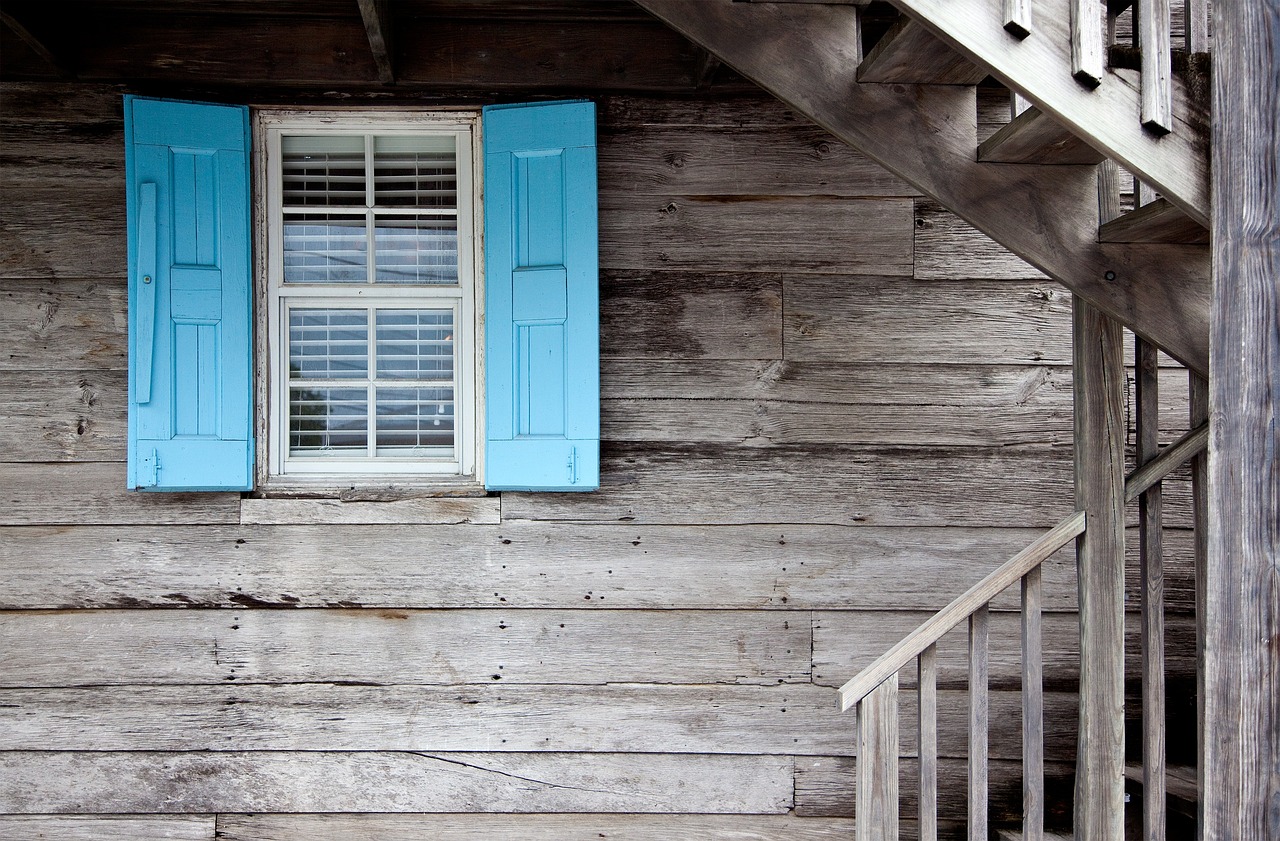un professionnel maçon en train de poncer la façade d'une maison en utilisant une ponceuse